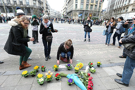 © APA/AFP/Belga/Nicolas Maeterlinck Menschen legen Blumen in Brüssel auf einen Platz