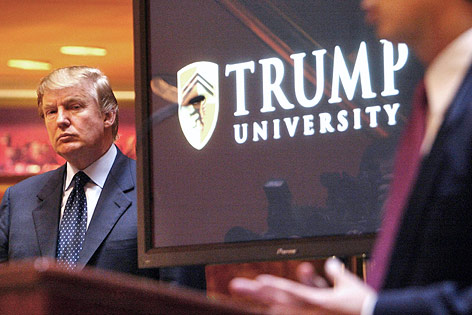 Donald Trump vor einem Bildschirm mit dem Logo der Trump University