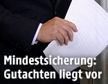 Mann h&auml;lt Gutachten in der Hand
