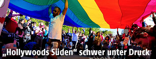 Menschen unter einer Regenbogenfahne