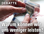 Mann h&auml;lt Geld in der Hand