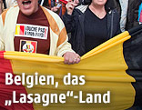 Mehrere Hände halten eine belgische Flagge