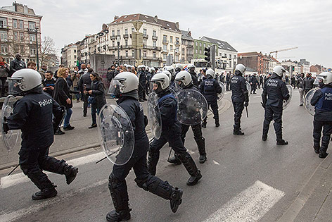 Polizisten sichern eine Demonstratin in Molenbeek