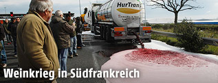 Demonstranten lassen Wein von einem Tankwagen ab
