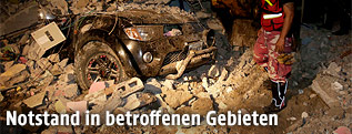 Beschädigtes Fahrzeug unter einem Haus