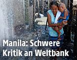 Frau in Manila geht im Wasserregen einer defekten Wasserleitung