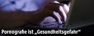 Mann sitzt an Laptop