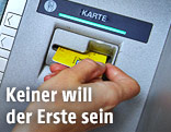Hand vor einem Bankomat