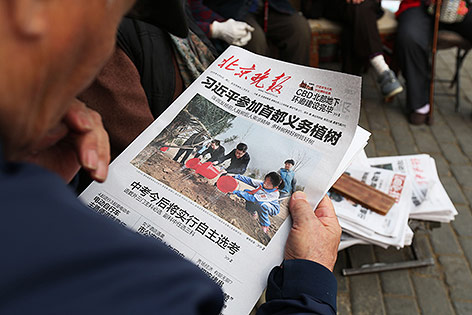 © APA/AFP Mann liest Chinesische Zeitung