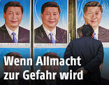 Mann steht vor Plakaten Xi Jingpings