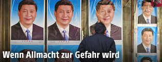 Mann steht vor Plakaten Xi Jingpings