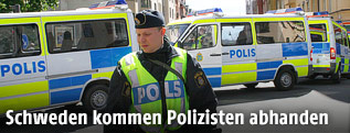 Schwedischer Polizist vor mehreren Polizeiautos