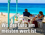 Urlauber sitzen am Strand in einer griechischen Taverne