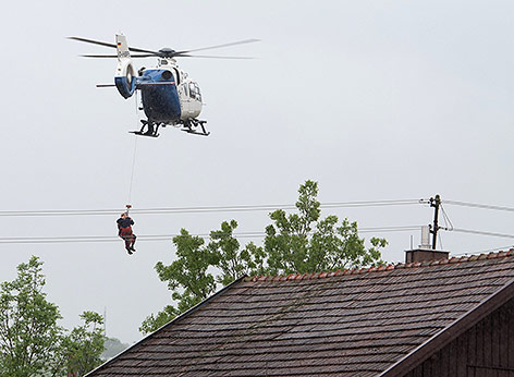 © APA/dpa/Armin Weigel Ein Hubschrauber der Polizei evakuiert eine Person in Triftern (Bayern)