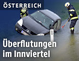 Feuerwehrleute bergen ein überflutetes Auto