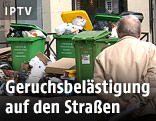 Mann geht an einem Müllberg in Paris vorbei