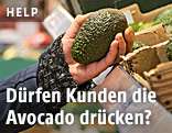 Avocado wird im Supermarkt gedrückt