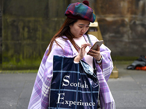 © APA/AFP/Oli Scarff Eine asiatische Touristin in schottischem Gewand