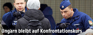 Ungarische Polizei an der Grenze mit einem Flüchtling