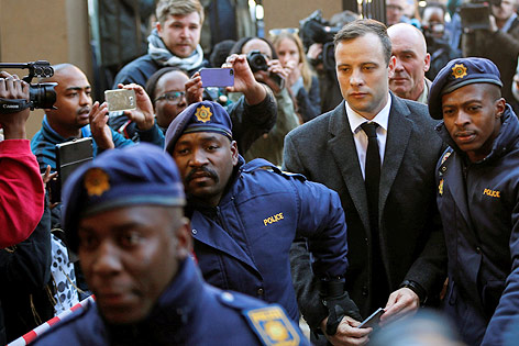 Den ehemalige südafrikanische Sportstar Oscar Pistorius von Polizisten eskortiert auf dem Weg zum Gericht