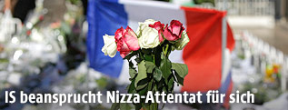 Blumen vor einer französischen Fahne