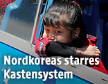Mädchen in Nordkorea blickt aus der Strassenbahn