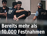 Türkische Polizisten führen einen türkischen Mann ab