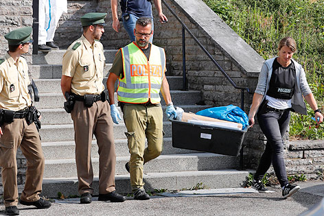 © AP/Matthias Schrader Polizisten tragen Beweisstücke