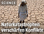 Ein Mann steht auf ausgedörrtem Boden