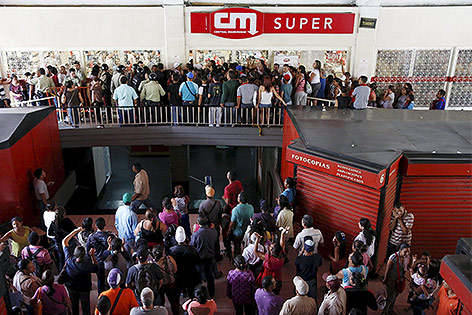 © Reuters/Carlos Garcia Rawlins Menschen stellen sich vor einem Supermarkt in Caracas an