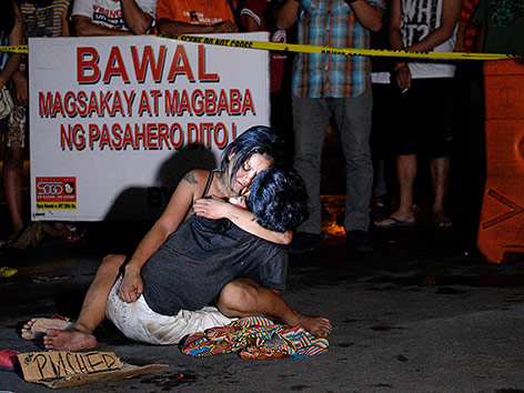 © APA/AFP/Noel Celis Frau hält einen Verstorbenen