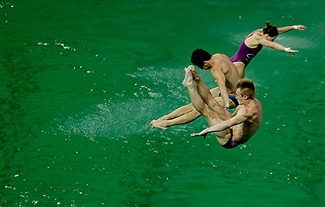 © AP/Matt Dunham Athleten absolvierenTrainingssprünge ins grüne Wasser in Rio