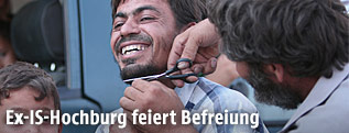 Einem Mann wird der Bart abgeschnitten