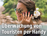 Eine Frau mit Mobiltelefon an einem thail&auml;ndischen Strand