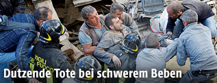 Feuerwehrleute retten einen Überlebenden aus den Trümmern