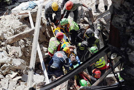 © APA/AP/Andrew Medichini Feuerwehrleute retten einen Überlebenden aus den Trümmern