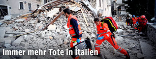 Helfer auf den Trümmern eines zerstörten Haus