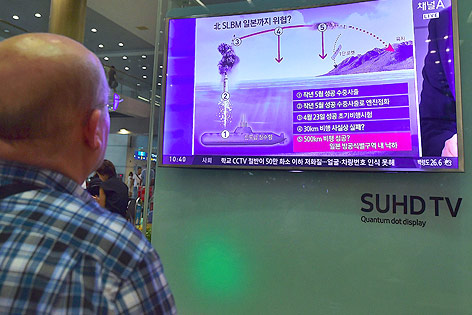 © APA/AFP/Jung Yeon-Je Ein Südkoreaner sieht sich auf einem TV-Gerät eine Grafik zum nordkoreanischen U-Bootraketentest an