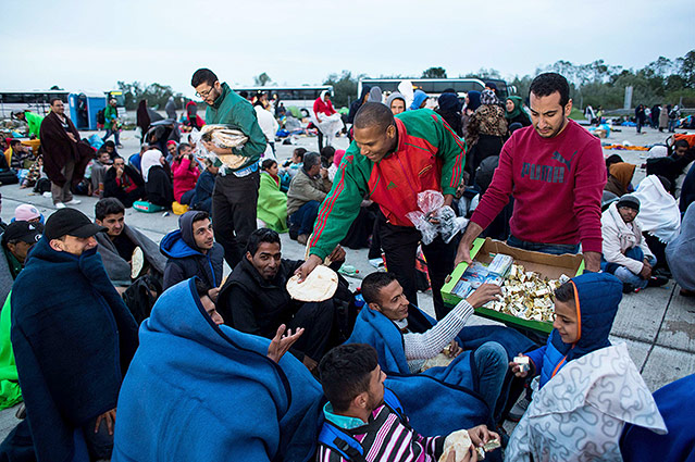 © APA/AFP/Vladimir Simicek Helfer verteilen an wartende Flüchtlinge in Nickelsdorf Essen