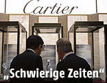 Zwei Männer blicken in eine Vitrine mit einer Cartier-Uhr