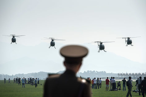 © APA/AFP/Ed Jones Vier Hubschrauber vom Typ Hughes MD-500 bei der Flugshow in Nordkorea
