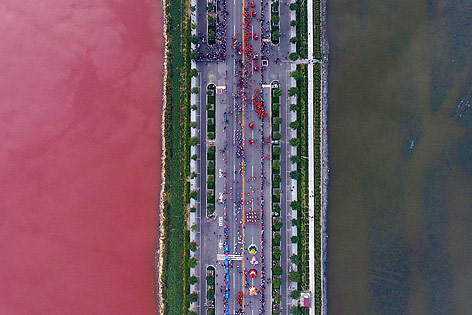 © Reuters/China Stringer Network Straße über einen Salzsee in Yuncheng (China), der auf Grund von Algen auf einer Seite rot gefärbt ist
