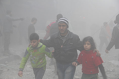 © picturedesk.com/Imageslive/Louai Barakat Ein Syrer entkommt mit zwei Kindern einem Luftangriff