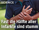 Mann greift sich ans Herz