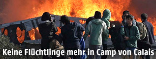 Flüchtlinge stehen vor Feuer in Calais