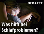 Frau mit Handy in einem Bett