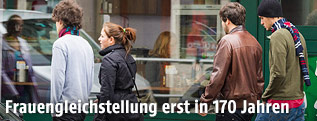Straßenszene mit einer jungen Frau und drei Männern