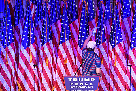 © APA/AFP/Jim Watson Mann saugt US-Fahnen
