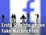Figuren vor einem Facebook-Logo