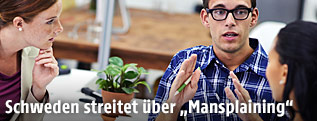 Intelligent wirkender Mann spricht mit zwei Frauen